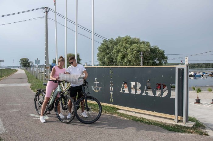 Két kerékpáros térképet olvas az Abádi Kikötő előtt